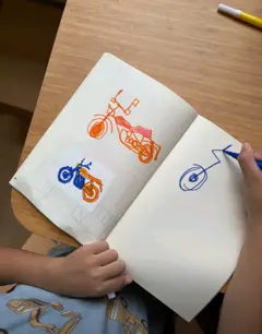 Customer photo: a Stickr motorbike print with a child's drawing beside it